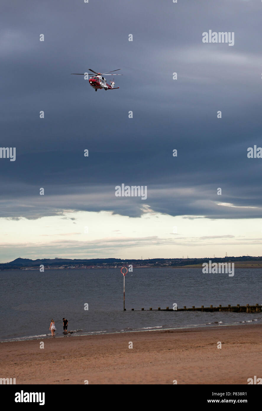 Edinburgh, Regno Unito. 08 luglio 2018. Portobello Beach, Edimburgo, Scozia, tra 7 pm e 9 pm di questa sera per la guardia costiera con quattro o più veicoli più un elicottero e una barca rinforzata conducendo una ricerca del litorale della spiaggia affollata, incidente sconosciuto Foto Stock