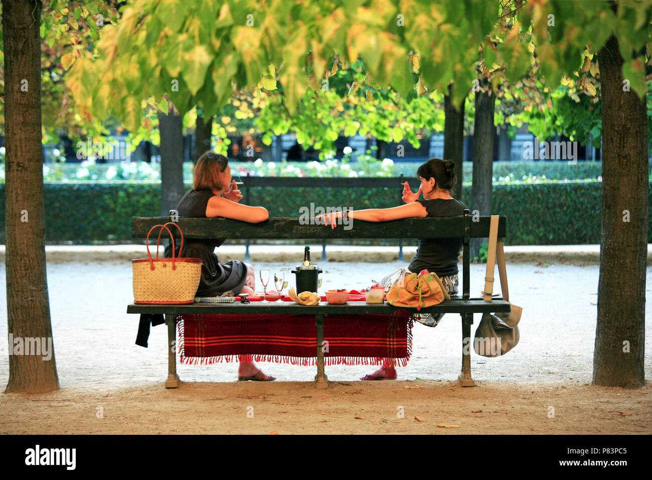 Due donne seduti su una panchina nel parco con picnic, Palais Royale giardini, Parigi, Francia, Europa Foto Stock