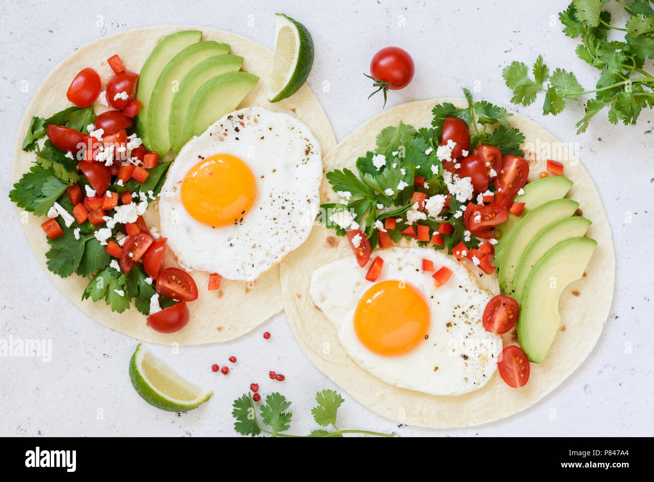 La colazione tortilla taco con uovo, avocado, salsa su sfondo luminoso, vista dall'alto Foto Stock