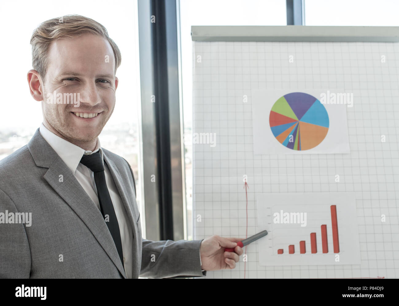 Uomo d'affari rendendo la presentazione di relazioni in diagrammi e grafici alla lavagna a fogli mobili in offfice Foto Stock