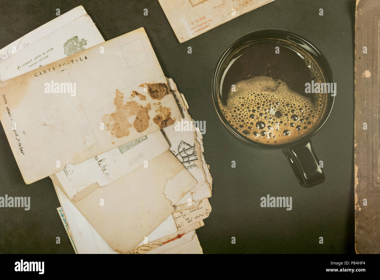 Tazza da caffè nei pressi di vecchie cartoline postali Foto Stock
