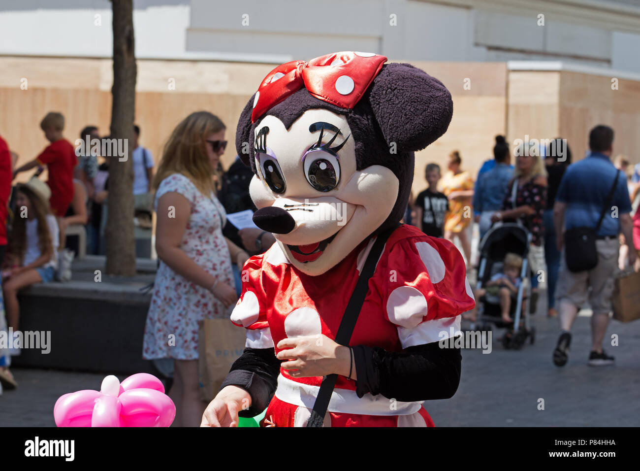 Street intrattenitore vestito come un Minnie Mouse vendere Funny shaped balloons al pubblico in Liverpool Regno Unito. Foto Stock