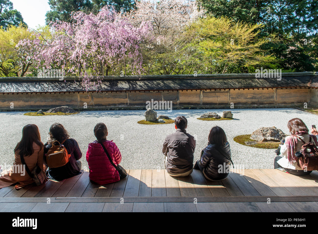 I turisti giapponesi godetevi la tranquillità presso il Tempio di Ryoanji a Kyoto, in Giappone. Questo Zen tempio Buddista è famosa per il suo giardino di roccia. Foto Stock