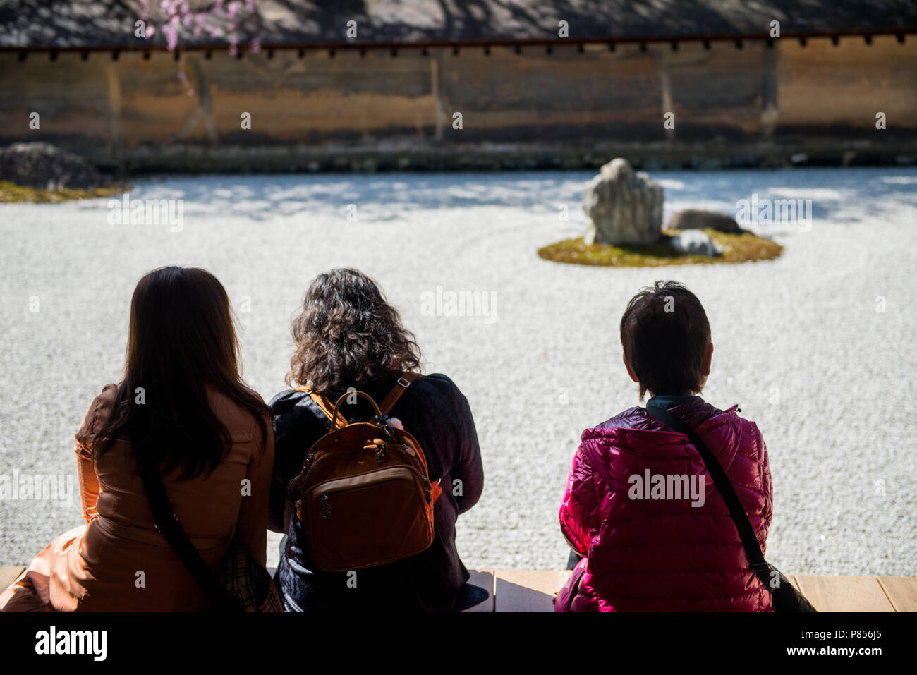 I turisti giapponesi godetevi la tranquillità presso il Tempio di Ryoanji a Kyoto, in Giappone. Questo Zen tempio Buddista è famosa per il suo giardino di roccia. Foto Stock