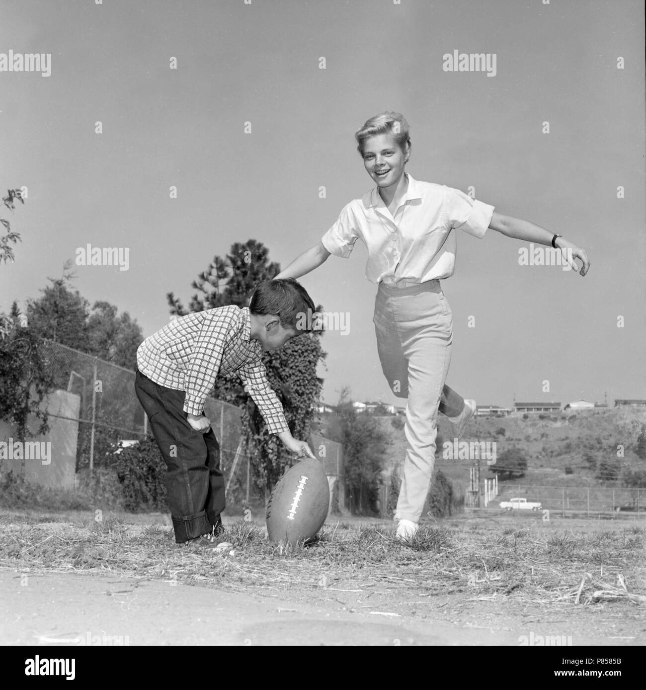Giovane donna si prepara a giocare a calcio, ca. 1965. Foto Stock