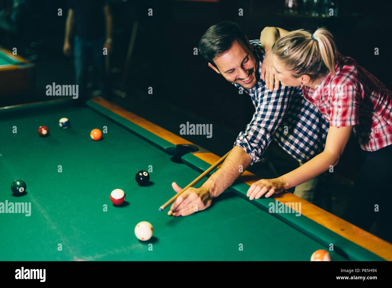 Coppia giovane giocare biliardo insieme in bar Foto Stock