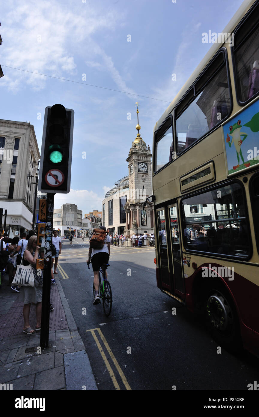 Scena di strada con Bus & ciclista traffico passante luce in Brighton, Inglese la cittadina sul mare, Brighton & Hove, East Sussex, England, Regno Unito Foto Stock