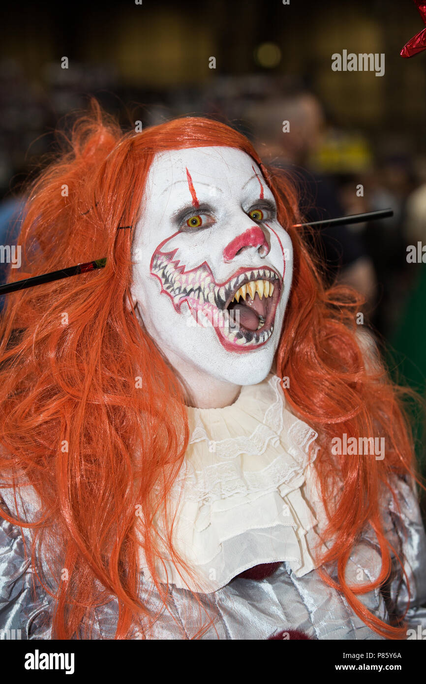 Una femmina di cosplayer vestito come Pennywise il clown dal romanzo Stephen King e filmato a un fumetto con evento in Birmingham, Regno Unito Foto Stock