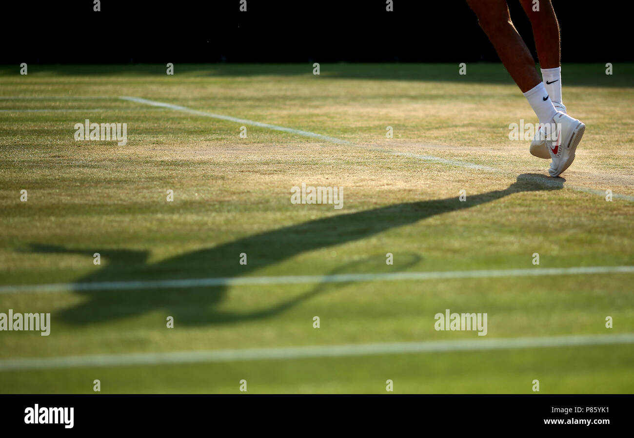 L'ombra di Juan Martin del Potro come egli serve il 7° giorno del Wimbledon Championships all'All England Lawn Tennis and Croquet Club, Wimbledon. PREMERE ASSOCIAZIONE foto. Data immagine: Lunedì 9 luglio 2018. Vedi PA storia TENNIS Wimbledon. Il credito fotografico dovrebbe essere: Steven Paston/PA Wire. Foto Stock