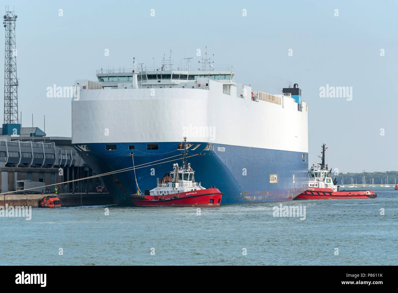 Rimorchiatori Buffalo e SD Stingray accanto al destino Viking un auto vettore nave. Spostare il vaso dalla banchina di ormeggio nel porto di Southampton, England Regno Unito. Foto Stock