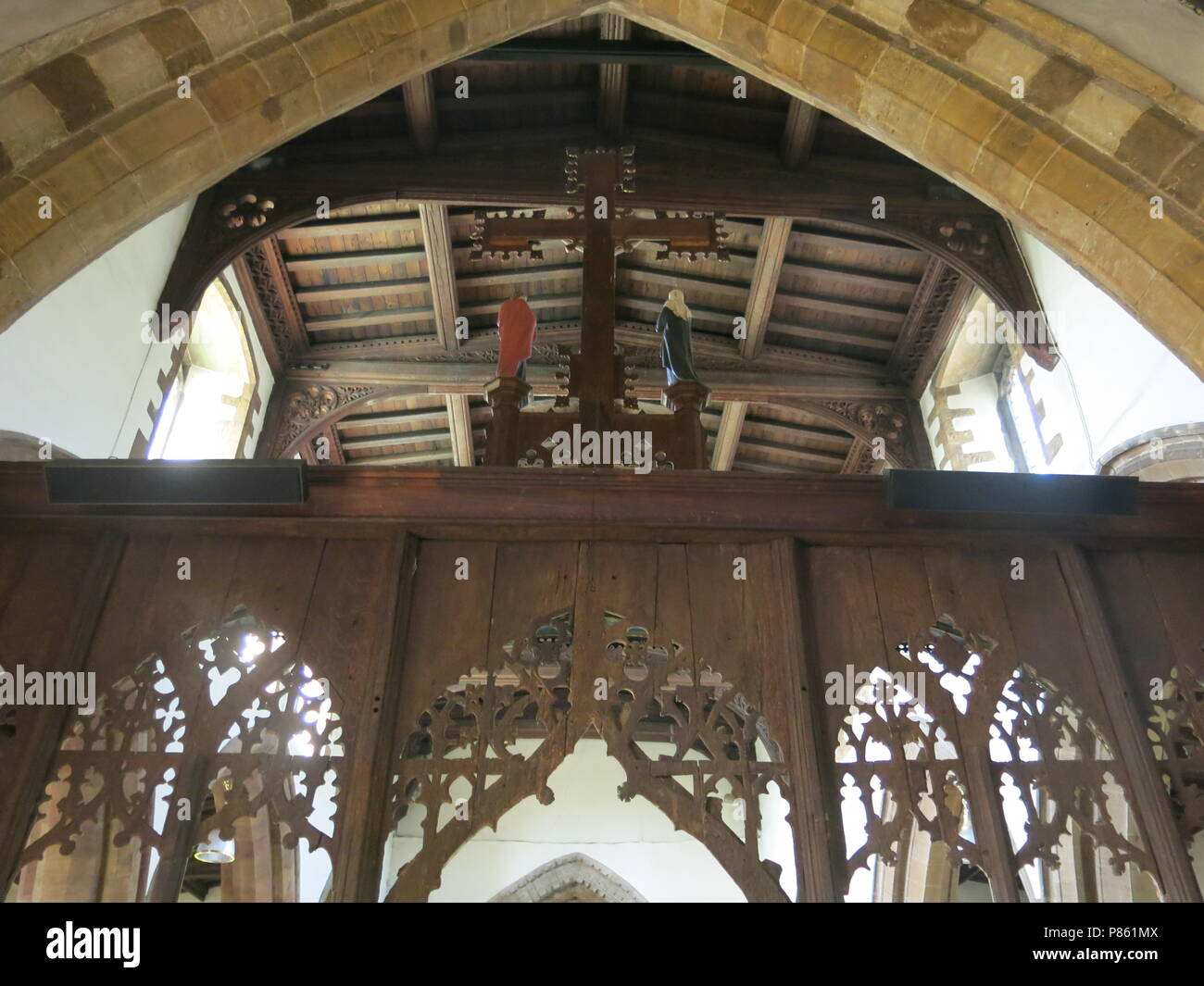 Una vista guardando indietro attraverso il XV secolo rood screen dal coro alla navata centrale all'interno della chiesa sassone, tutti i Santi, a Earls Barton Foto Stock