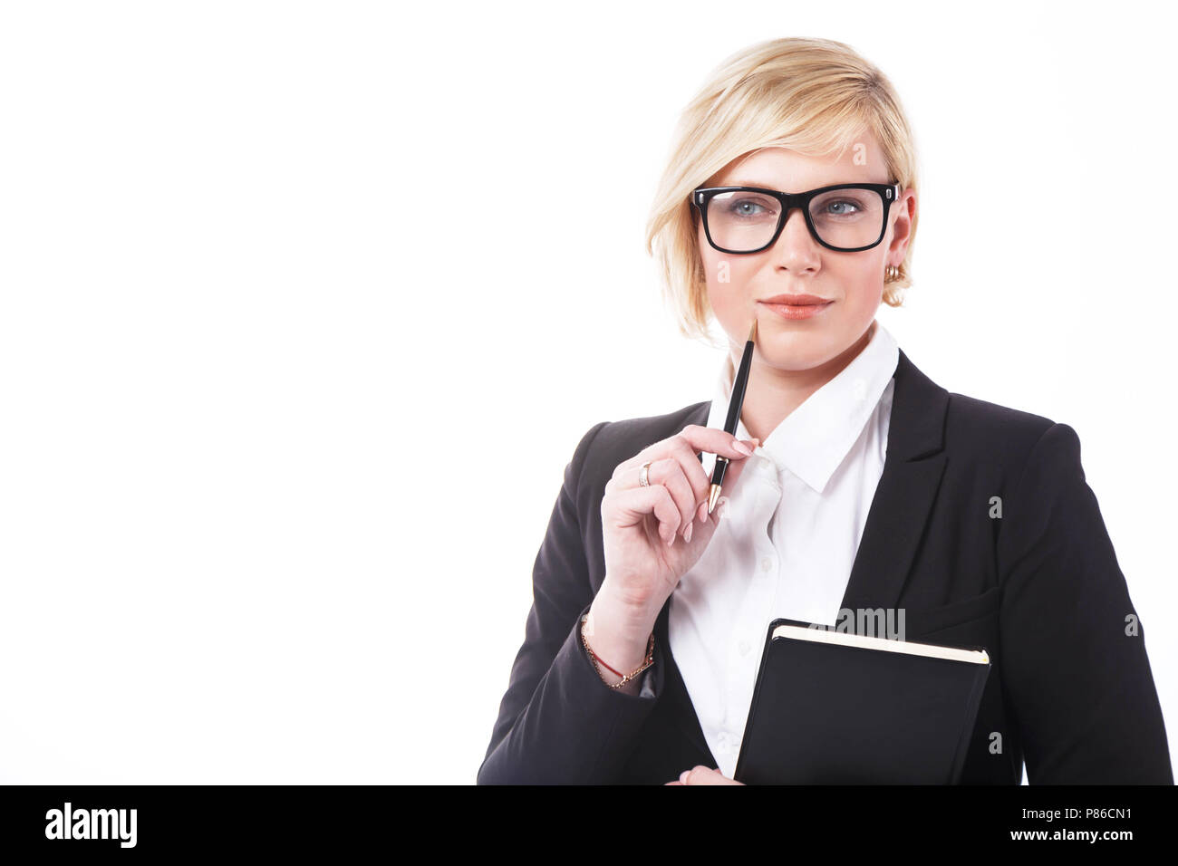Bella businesslady adulti vestiti in giacca nera e occhiali azienda notebook e penna prima di sfondo bianco con copyspace Foto Stock