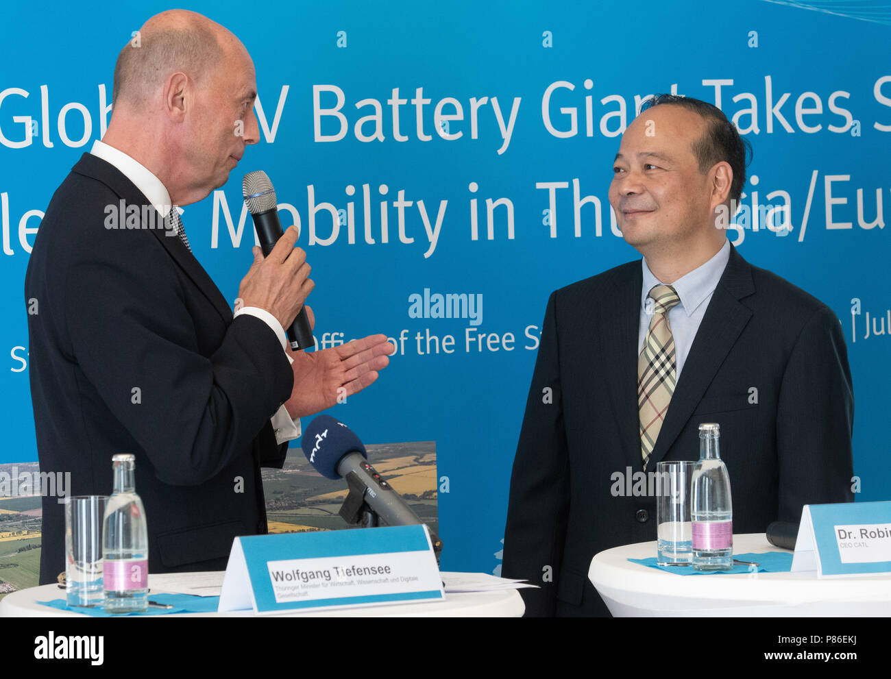 Berlino, Germania. 09 Luglio, 2018. Il Land Turingia è il ministro dell'Economia Wolfgang Tiefensee del Partito socialdemocratico (SPD) e il CEO della batteria cinese contemporanea produttore Amperex Technology Ltd (CATL), Robin Zeng (R), presentare i piani per la costruzione di una fabbrica della società cinese in Turingia. Piani CATL per produrre le celle della batteria per auto electro in Turingia. Credito: Paolo Zinken/dpa/Alamy Live News Foto Stock