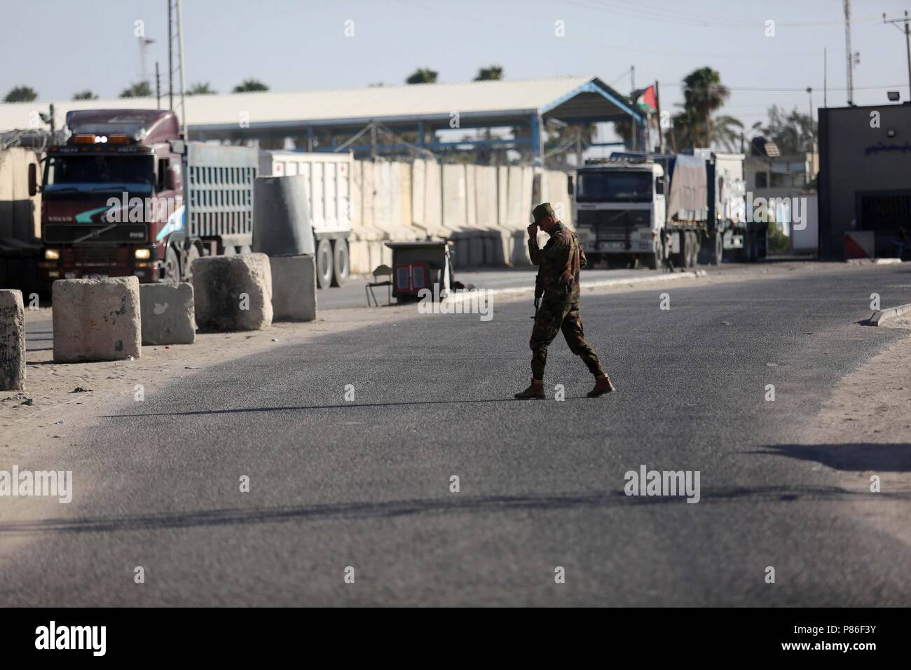 9 luglio 2018 - Rafah nella striscia di Gaza, Territori palestinesi - palestinesi stare vicino al cancello di Kerem Shalom crossing, nella città di Rafah nel sud della striscia di Gaza il 9 luglio 2018. Israele ha chiuso il suo solo attraversamento con la striscia di Gaza il lunedì per settimane di incendi presso le aziende agricole causati da aquiloni e palloncini che trasportano firebombs dall'enclave palestinese. Il gli attacchi incendiari hanno portato alla crescente allarme tra i residenti israeliani e gli agricoltori vicino al bloccato nella Striscia di Gaza e chiede che le autorità ad agire. ''L'attraversamento verrà chiusa tranne che per le attrezzature umanitarie (inclusi alimenti e medicin Foto Stock