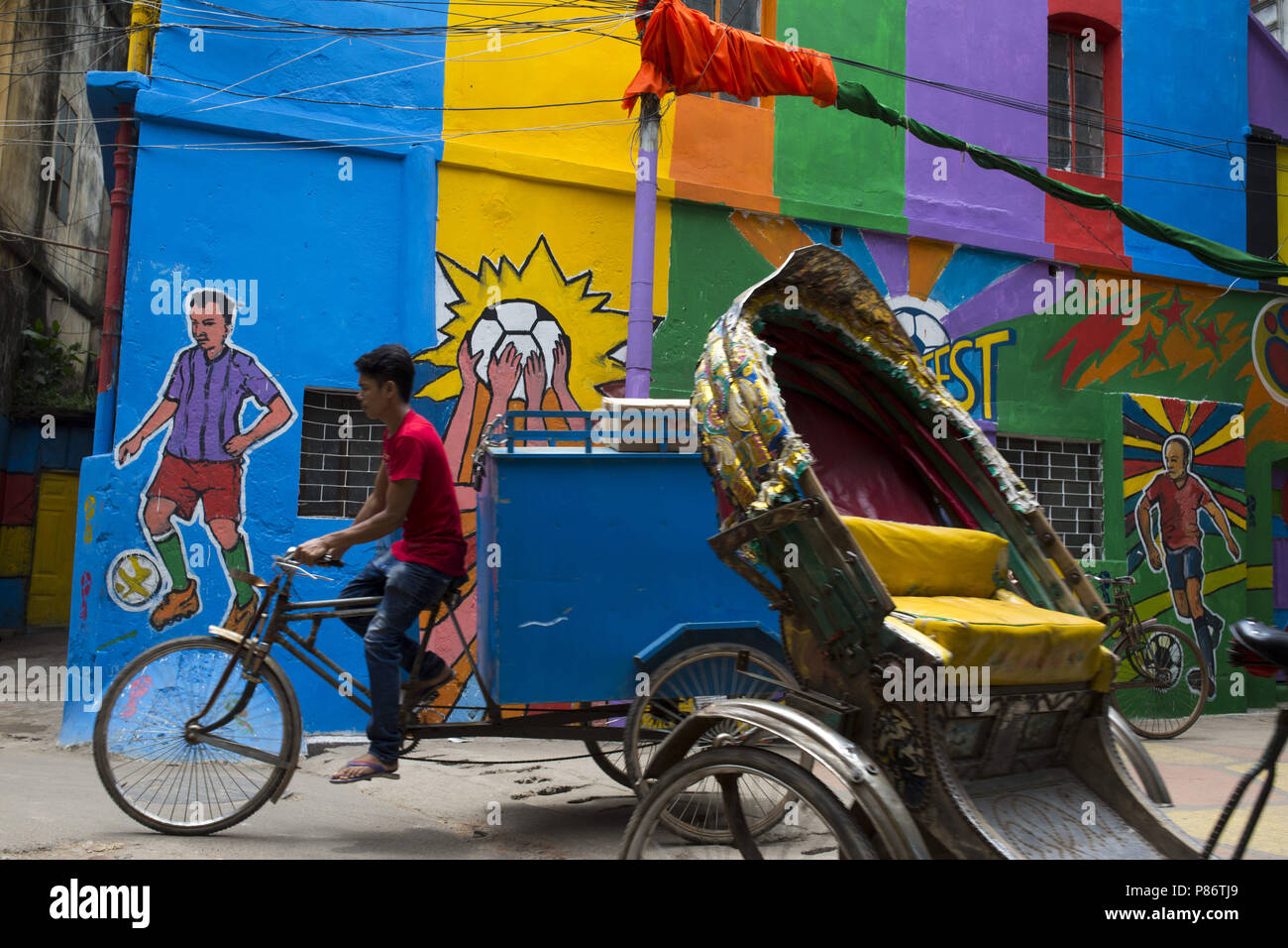 Luglio 10, 2018 - Dhaka, Bangladesh - Dhaka, Bangladesh - 10 Luglio : popolo del Bangladesh passeggiate attraverso accanto a una parete dipinta da appassionati di calcio durante il 2018 FIFA World Cup in Russia a Dhaka , Bangladesh sulla luglio 10, 2018...bangladese i tifosi di calcio è diventato pazzo durante la Coppa del Mondo e uno sforzo per attirare l'attenzione delle loro squadre favorite da bandiere issate sulle pareti delle loro case,dipinto sulla parete di strada e indossando squadre favorite Jersey. (Credito Immagine: © Zakir Hossain Chowdhury via ZUMA filo) Foto Stock