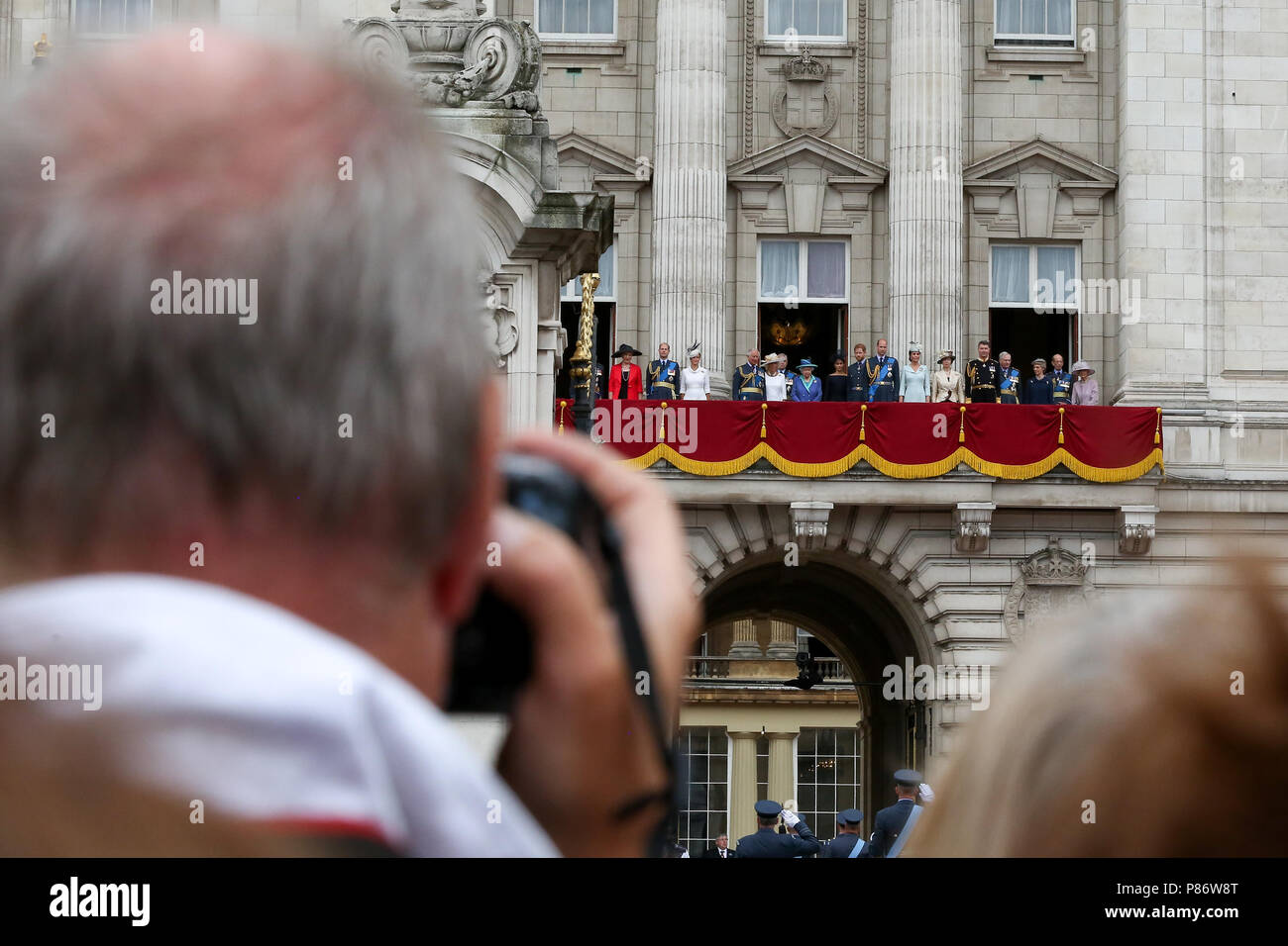 Il Mall. Londra. Regno Unito 10 luglio 2018 - HM la regina con la Principessa Michael del Kent, Prince Edward, Sophie Contessa di Wessex, il Principe Carlo, il principe Andréj, Camilla Duchessa di Cornovaglia, Meghan Duchessa di Sussex, il principe Harry, il principe William, Catherine Duchessa di Cambridge, Princess Anne e Tim Laurence come fino a100 aeromobile che rappresentano la RAF la storia tra cui le frecce rosse volare oltre Buckingham Palace per le celebrazioni del centenario della Royal Air Force. Credito: Dinendra Haria/Alamy Live News Foto Stock