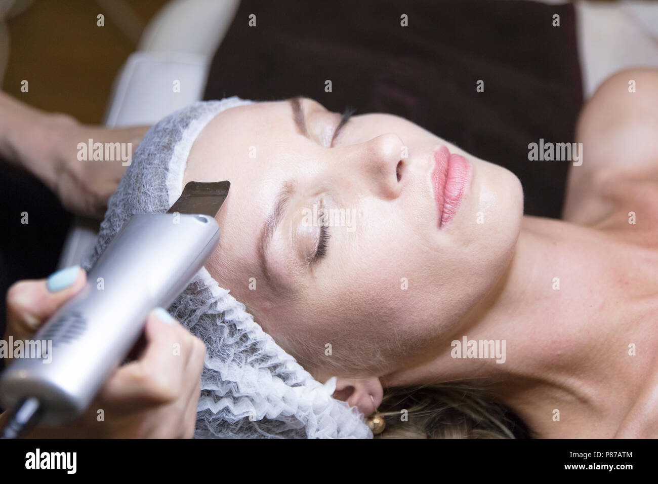 Closeup ritratto di donna e la mano con cosmetici dispositivo di sollevamento tocchino il suo volto Foto Stock