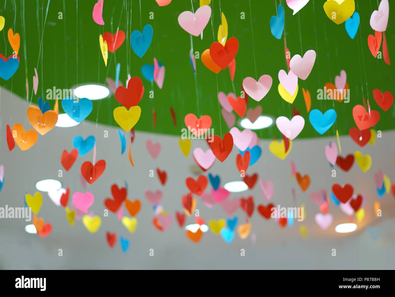 Cuore di carta mobili pensili. Carta colorata cuore sfondo. È possibile utilizzare questo cuore colorato sfondo per il vostro amore concept design. Foto Stock