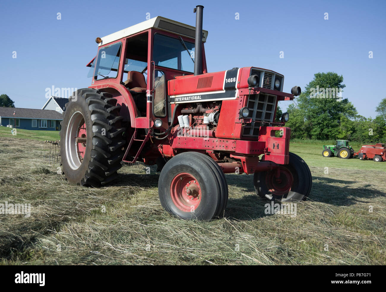 International Harvester modello diesel 1466 Trattore per filari in campo di fieno Foto Stock