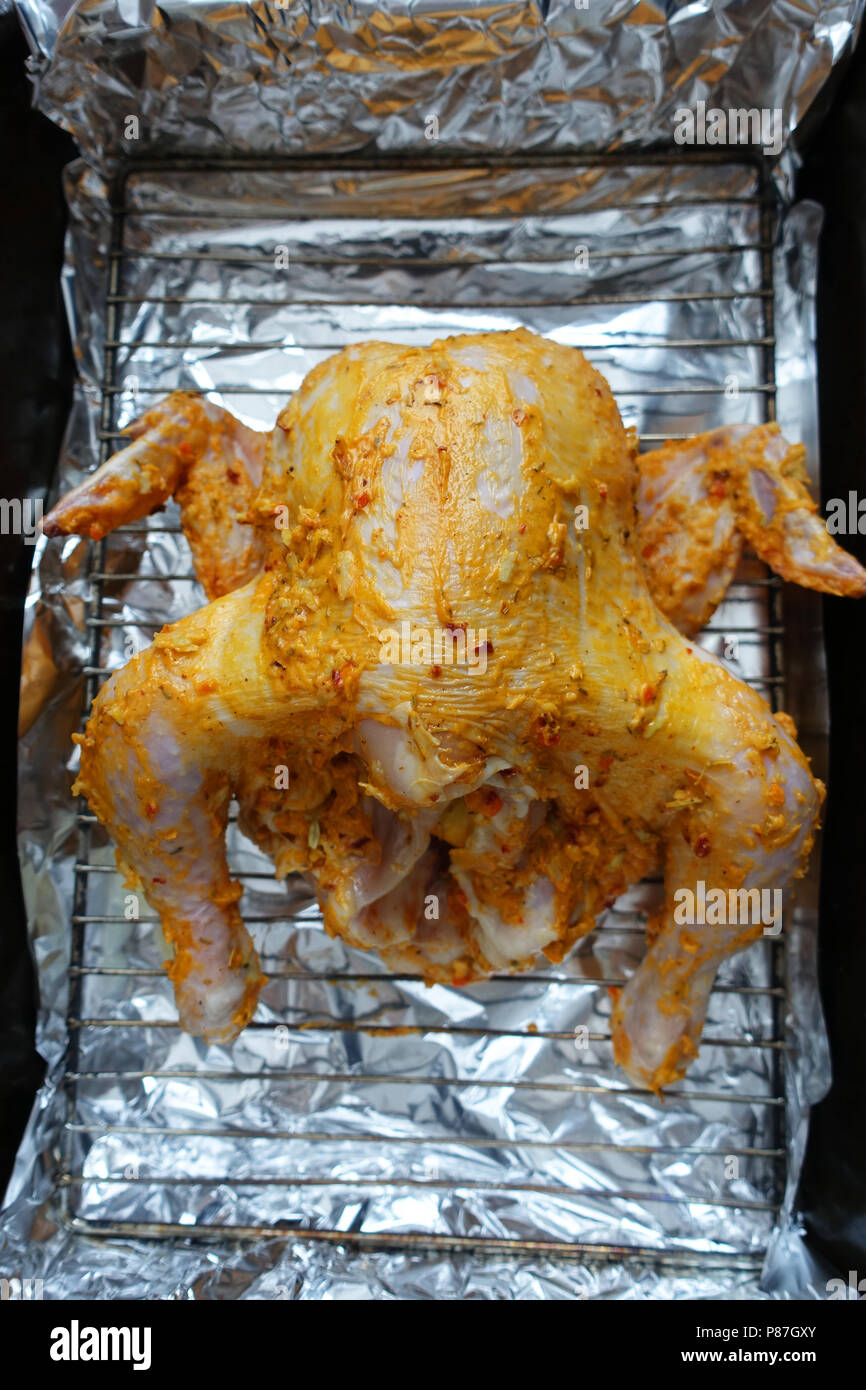 Marinata di pollo intero pronto per essere tostate in forno Foto Stock