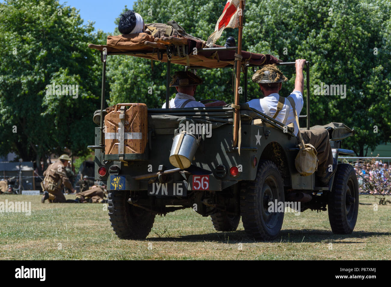 American jeep con fantoccio ferito sul tetto si muove per partecipare attore nei panni di un soldato ferito in guerra mondiale 2 skirmish demo per le forze armate di celebrazione Foto Stock