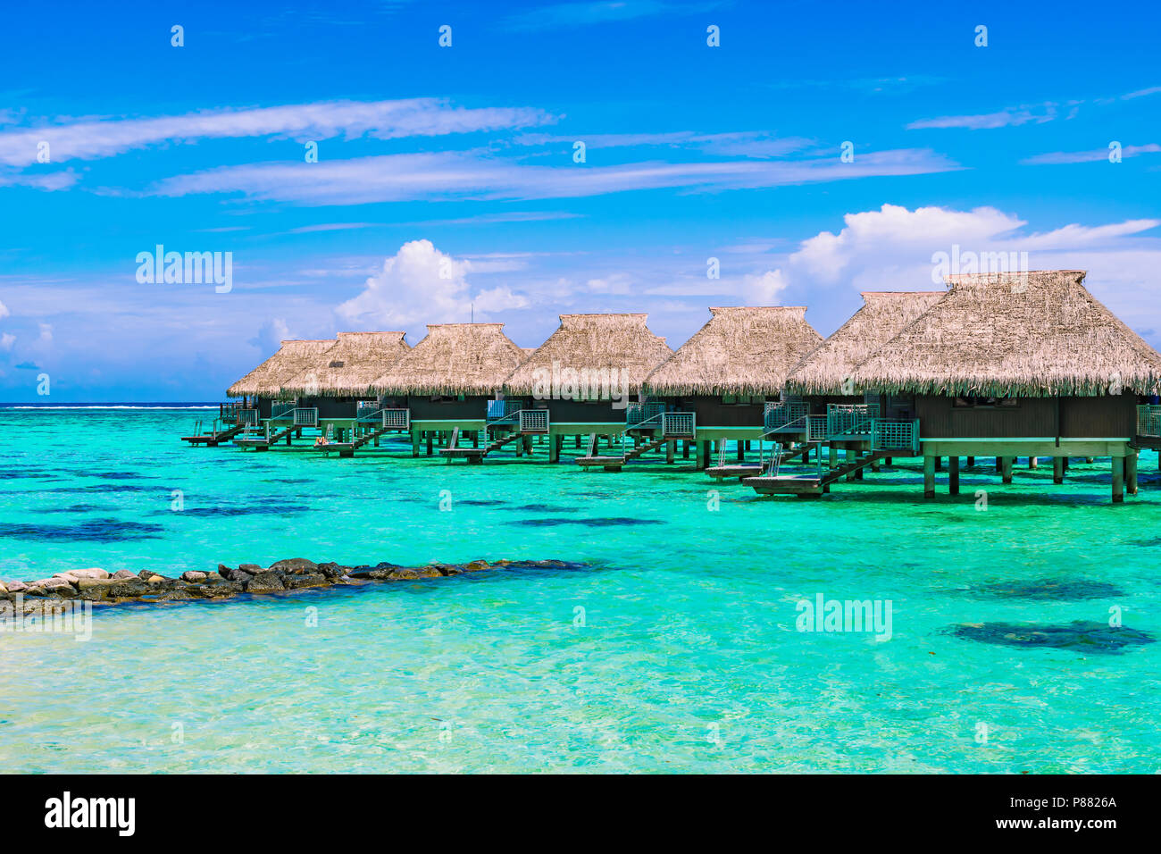 Spiaggia di lusso travel vacation concetto: bungalow Overwater sul turchese Coral Reef Ocean laguna vicino alla spiaggia. Foto Stock