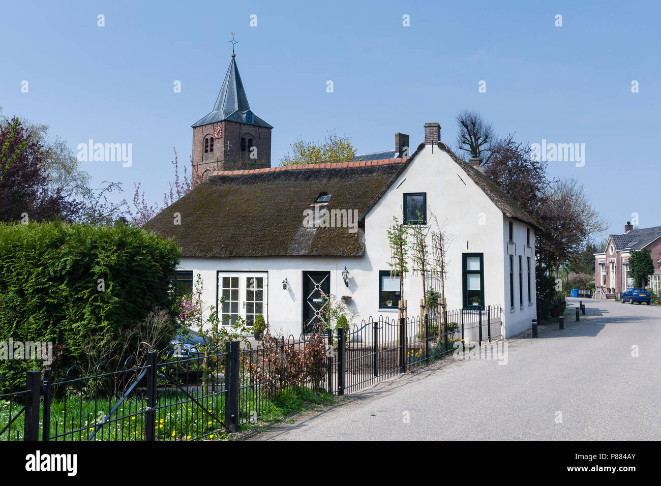 Casa di villaggio in Betuwe con chiesa in background Foto Stock