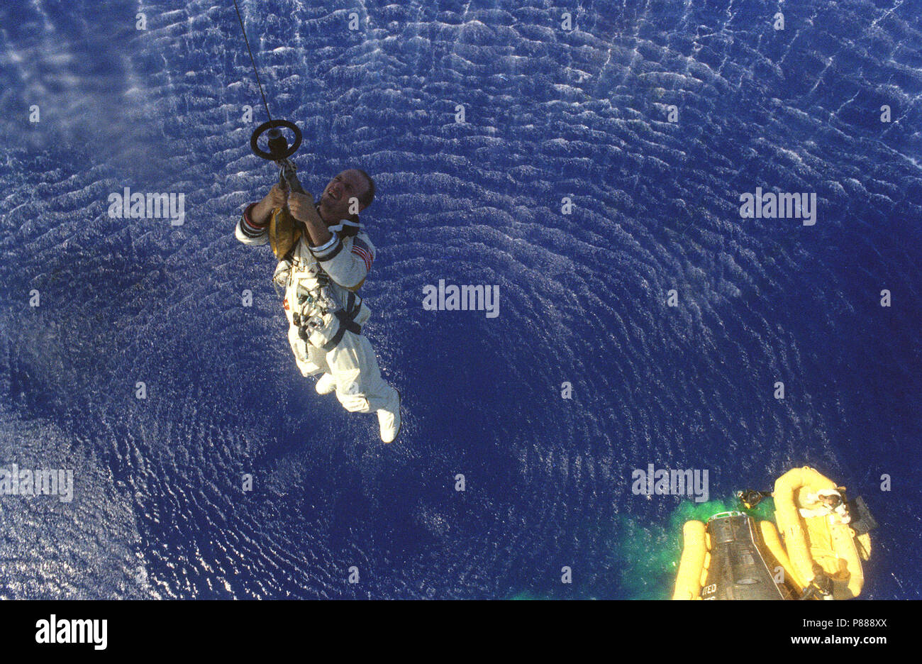 Astronauta Charles Conrad Jr è issato fino ad un elicottero della Marina Militare mentre astronauta L. Gordon Cooper Jr è in attesa in una zattera di salvataggio di seguito dopo aver splashdown della Gemini-5 veicoli spaziali Foto Stock