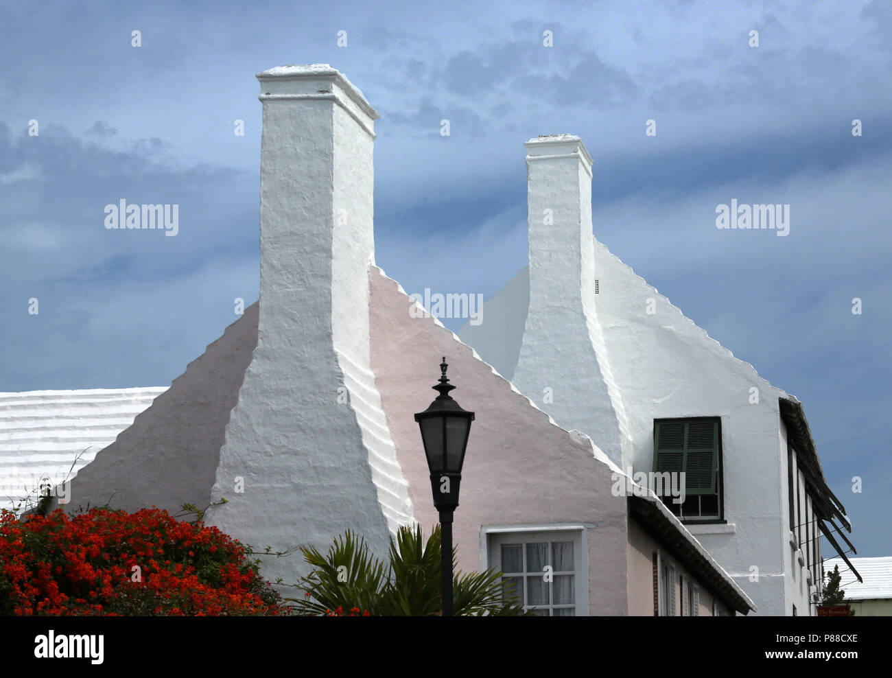 Bermudian stile architettonico con alte ciminiere e impregnata di tetti Foto Stock