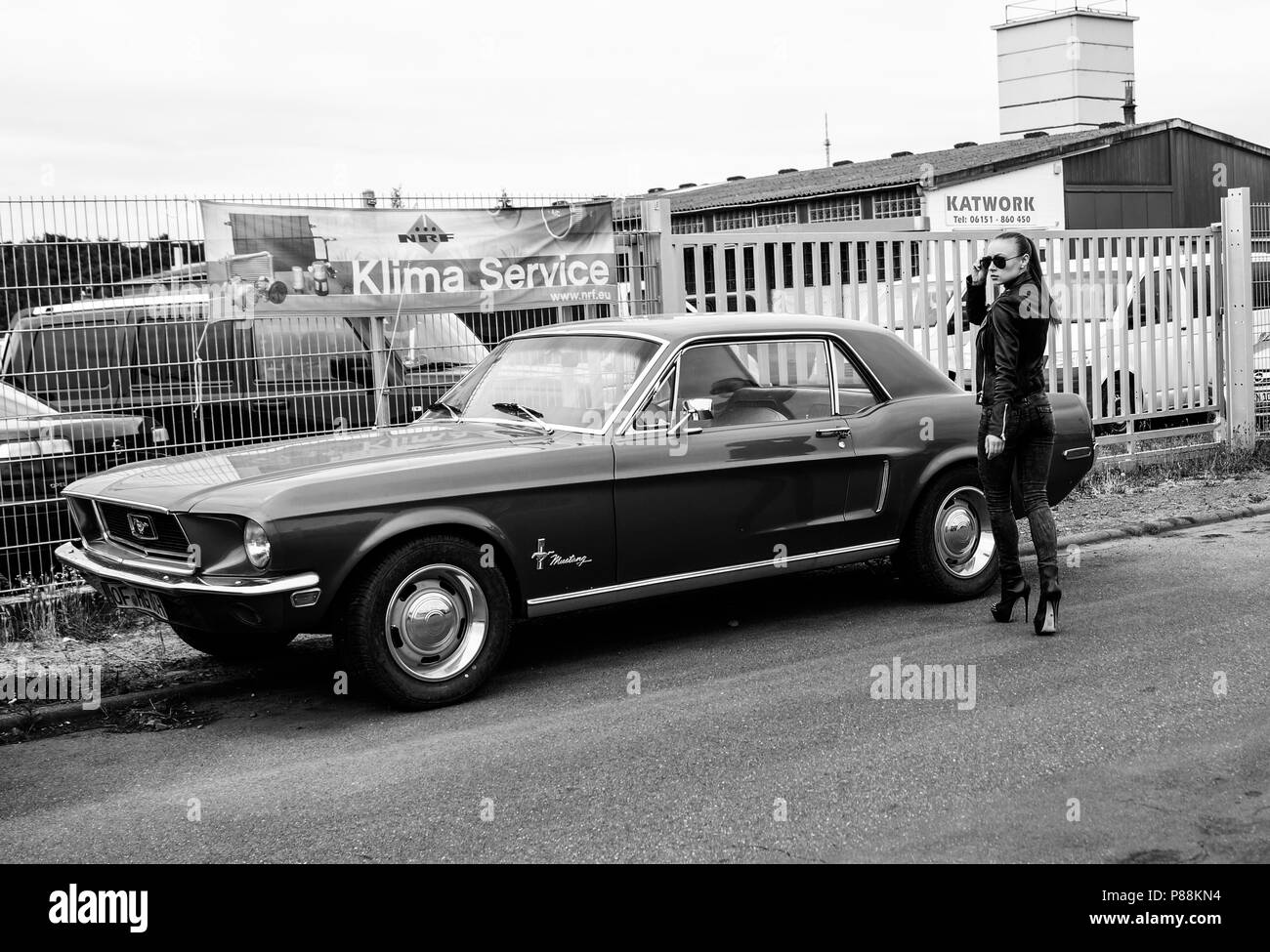 Modello femminile e vecchia auto. Ford Mustang. Foto Stock