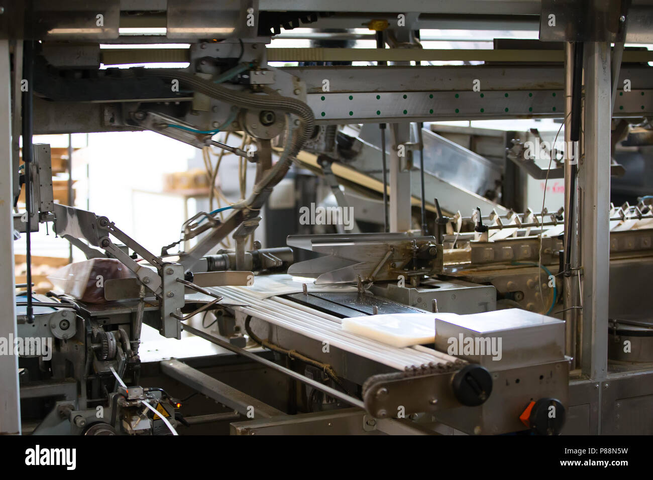 Linea industriale per il confezionamento di prodotti da forno. Confezionamento di pane in fabbrica.La macchina per il taglio e confezionamento in una fabbrica per la produzione Foto Stock