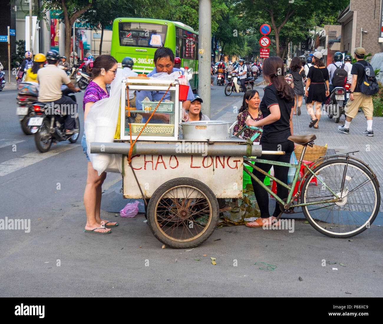 Il vietnamita venditore ambulante la vendita di cibo di strada Chao a lungo in Ho Chi Minh City Vietnam. Foto Stock