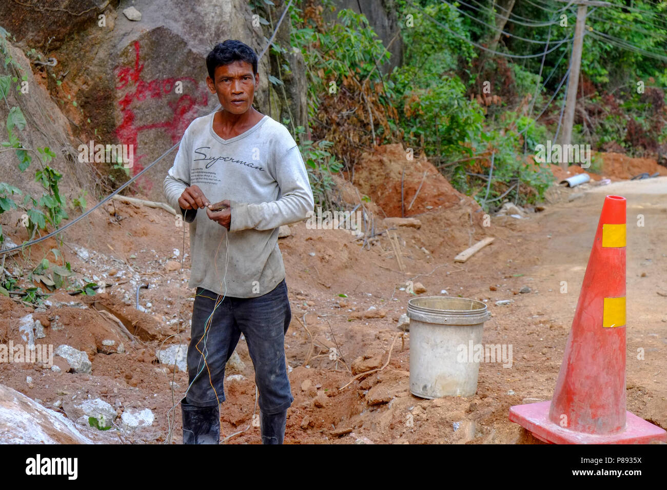 Lavoratori edili provenienti dal Myanmar sono la costruzione di nuove strade attraverso la giungla che copre le montagne dell'isola thailandese di Koh Phangan, Thailandia Foto Stock