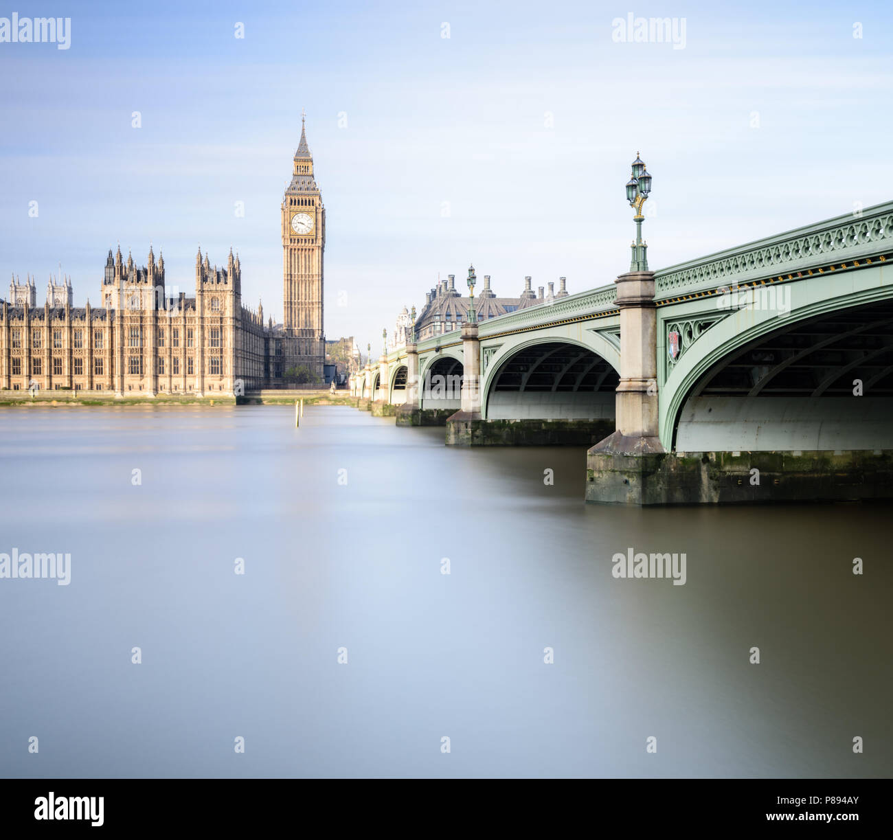 Il Big Ben e il Parlamento di Londra incluso Westminster Bridge si riflette nell'acqua liscia del Fiume Tamigi in una luminosa giornata di sole Foto Stock