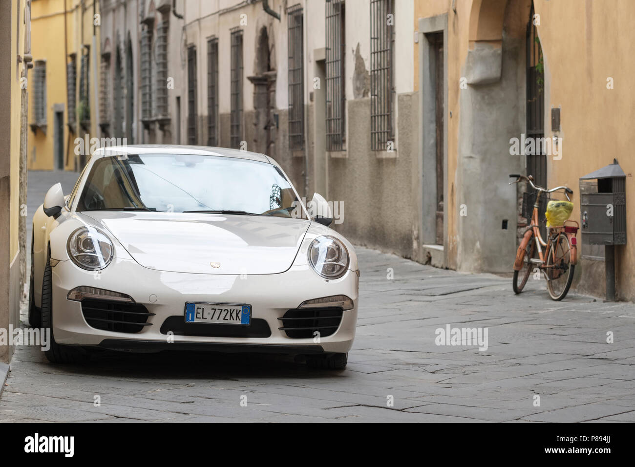 La Porsche 911 Carrera e la bicicletta, la vecchia strada di città di Lucca, Toscana, Italia, Europa Foto Stock