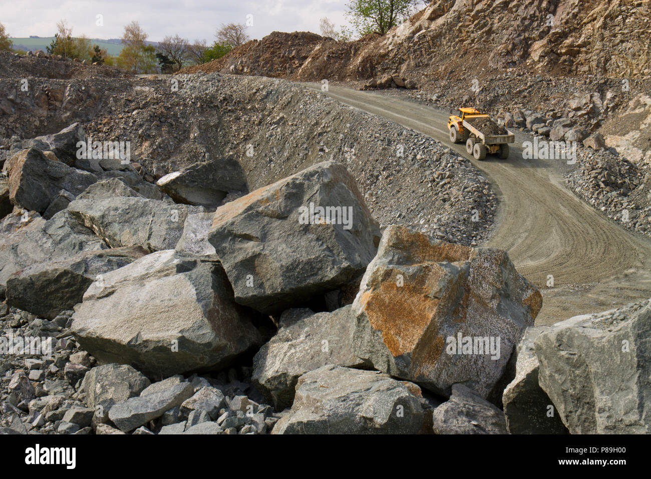 Estrattiva; una Volvo A40G dumper articolato trasporta un carico di pietra fuori della cava. Criggion cava, POWYS, GALLES. Aprile. Foto Stock