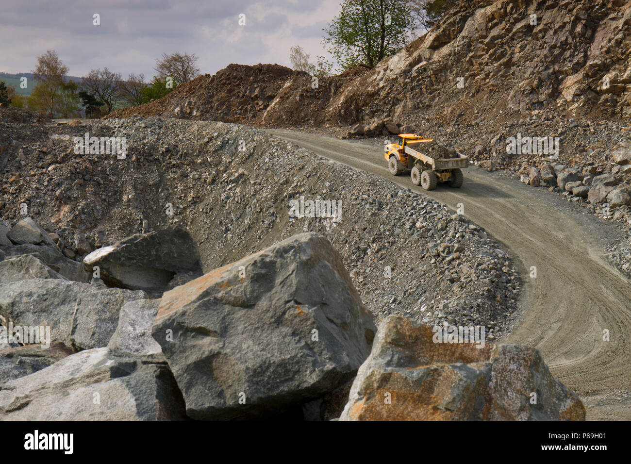 Estrattiva; una Volvo A40G dumper articolato trasporta un carico di pietra fuori della cava. Criggion cava, POWYS, GALLES. Aprile. Foto Stock
