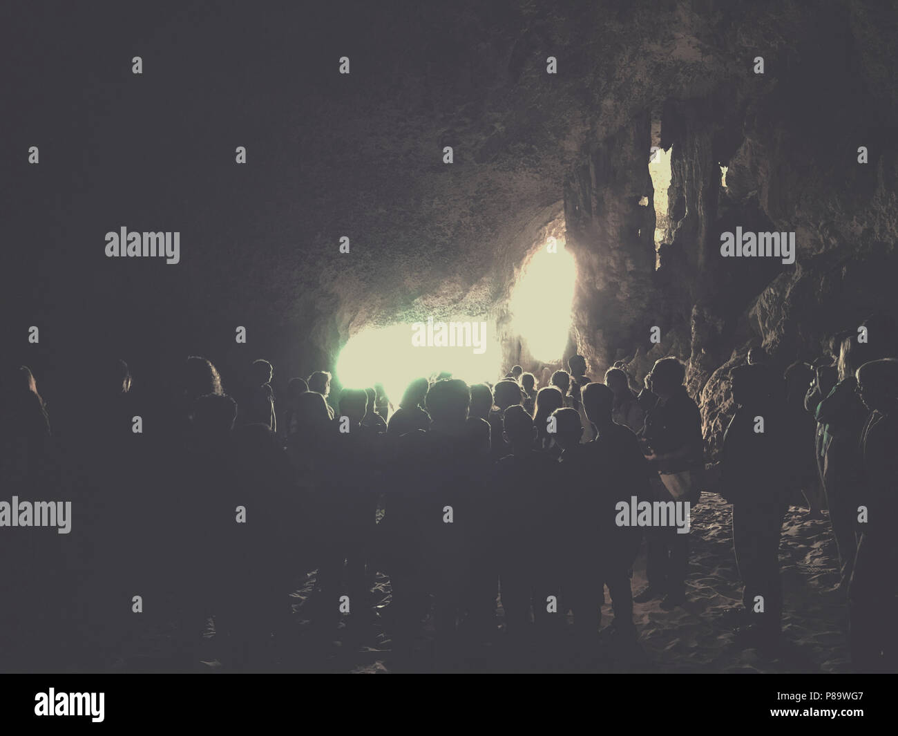 Raduno di persone all'interno della grotta a guardare la luce. La Grotta del Bue Marino presso il Golf di Orosei,Sardegna Foto Stock