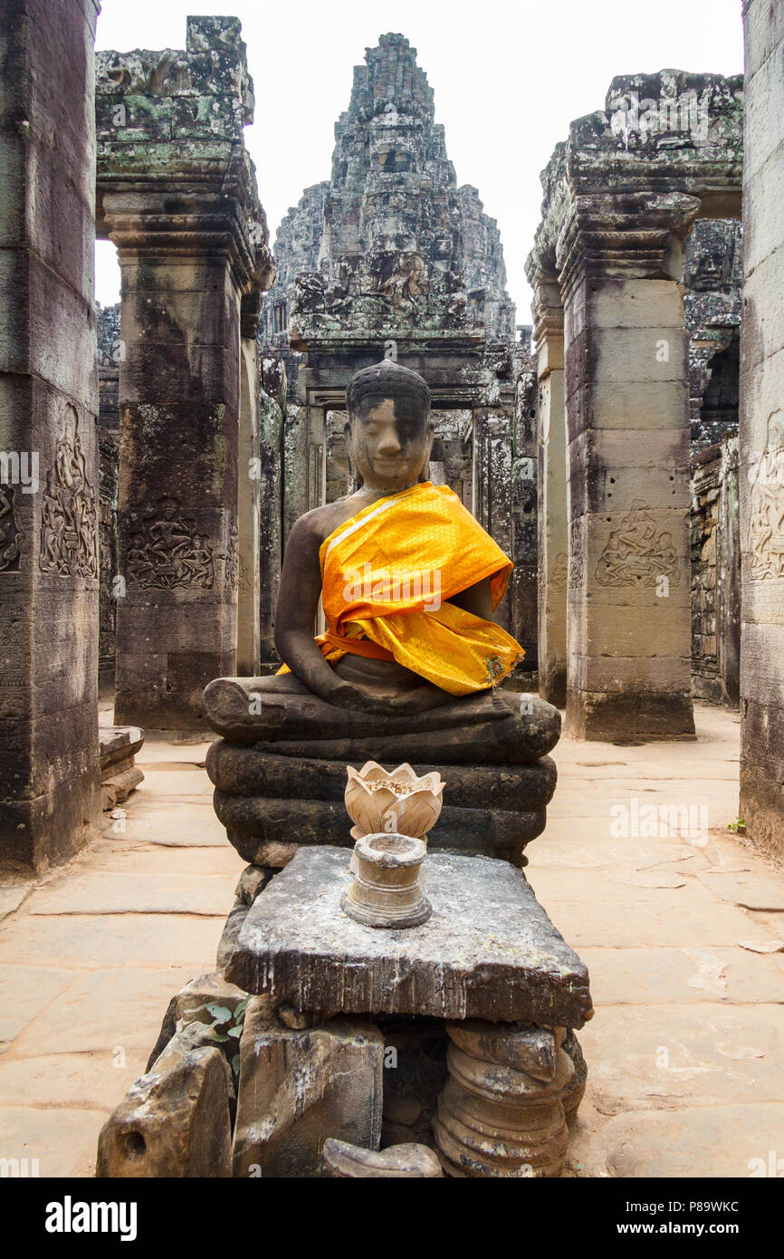 Buddista statua di pietra in tunica arancione, tempio Bayon, Angkor Thom, Cambogia Foto Stock