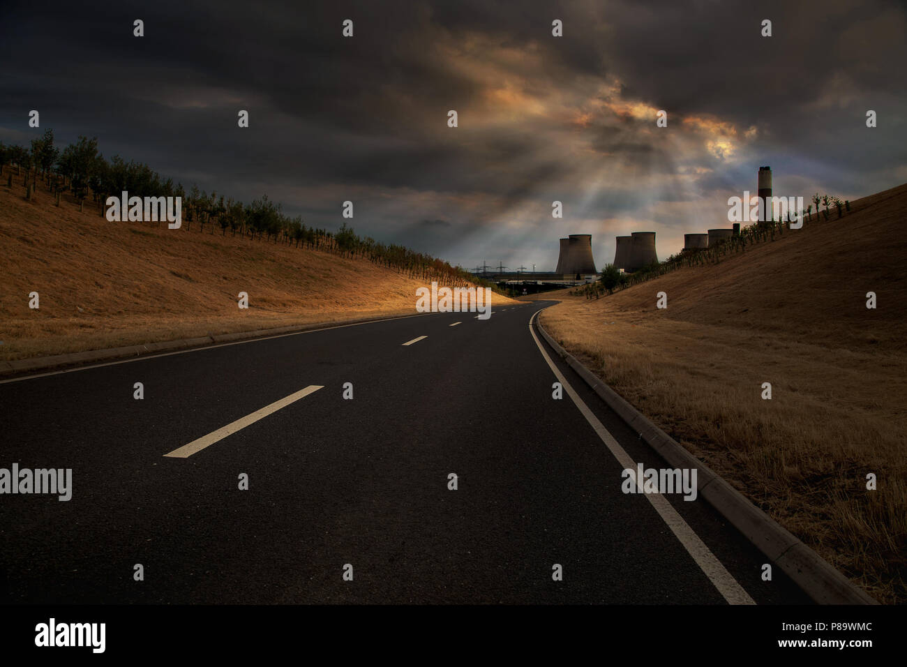 Cielo drammatico con raggi solari al di sopra di una strada di campagna che conduce a Ratcliffe su Soar Power Station, Nottingham, Inghilterra, Regno Unito, Europa Foto Stock