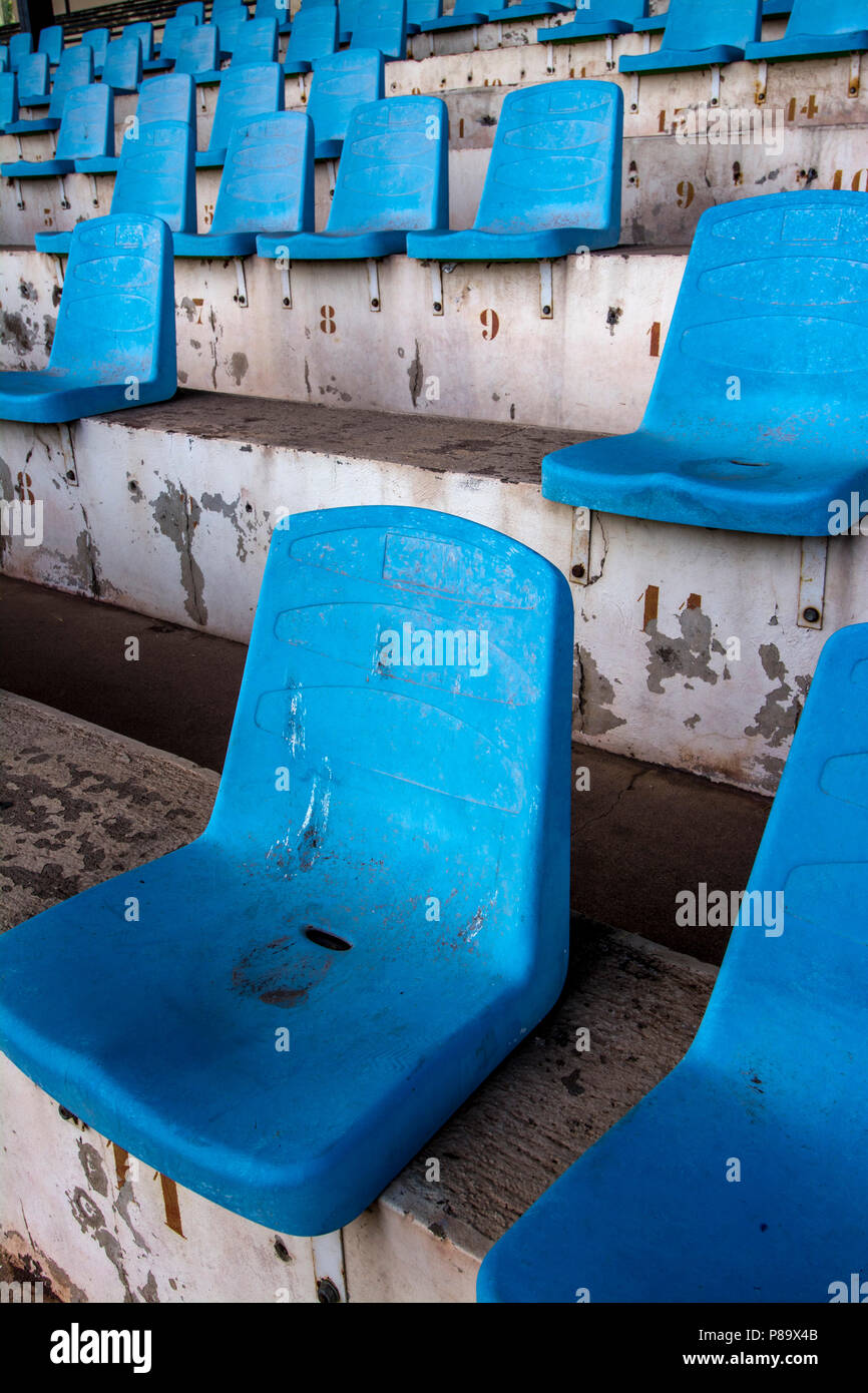 Inquadratura verticale ad alto angolo di uno stadio con vecchi posti a sedere blu numerati Foto Stock
