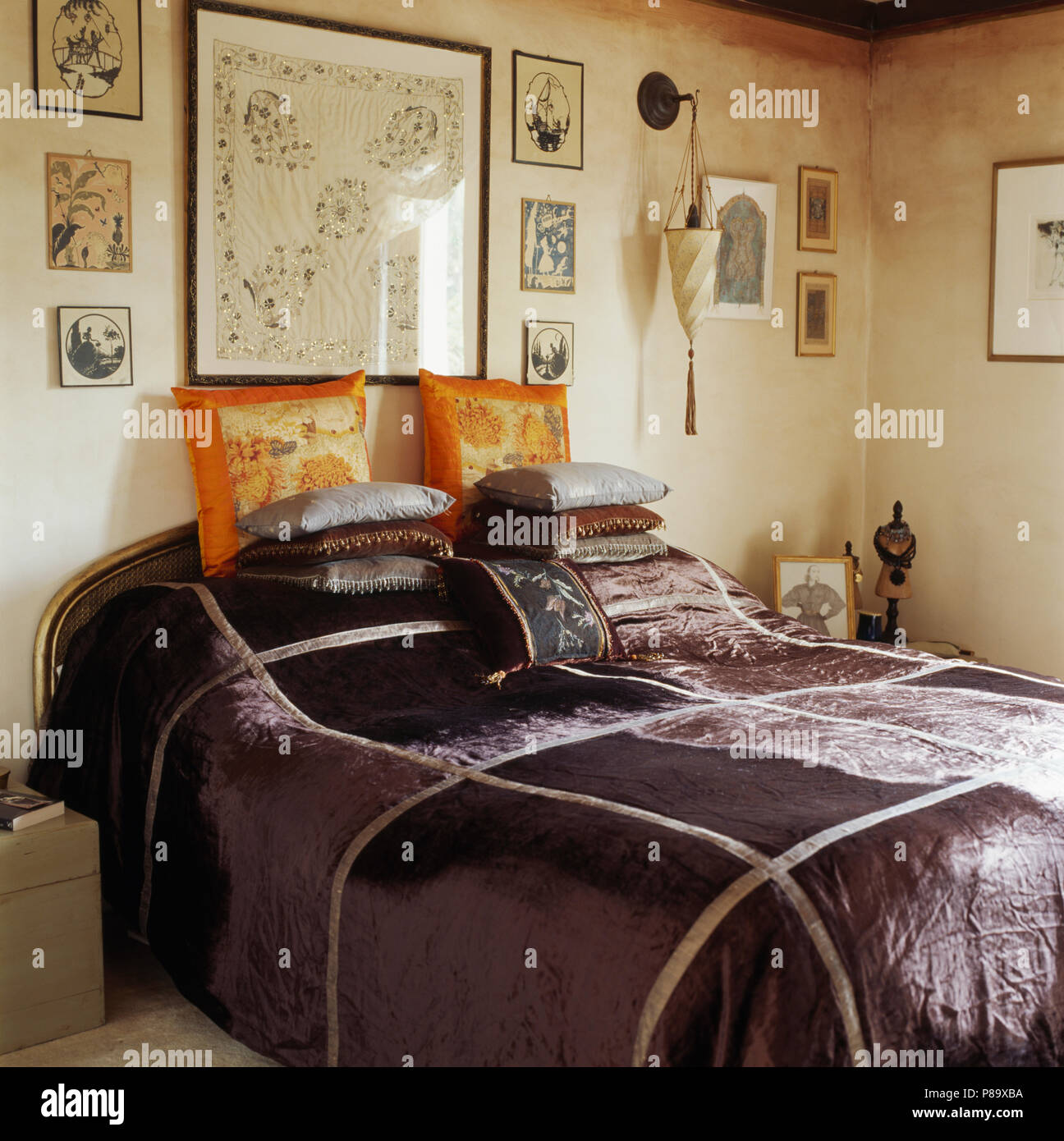Grigio scuro in velluto di seta mosaico sul letto impilati con cuscini in camera da letto townhouse Foto Stock