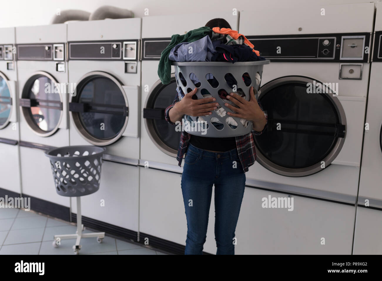 La donna che porta un cesto della biancheria Foto Stock