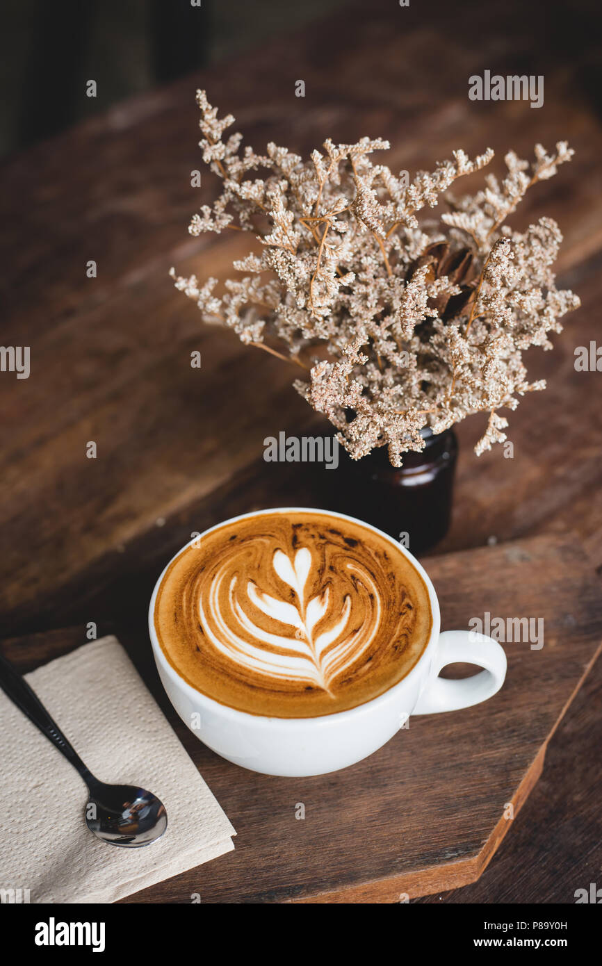 Tazza di latte caldo art caffè sul tavolo in legno Foto Stock