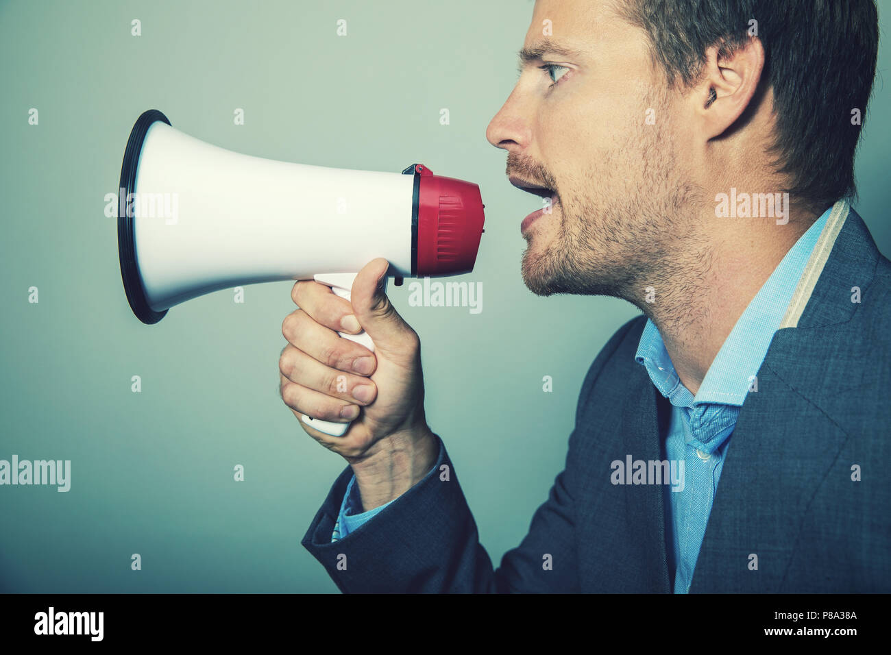 La leadership aziendale - imprenditore dando istruzioni con megafono Foto Stock