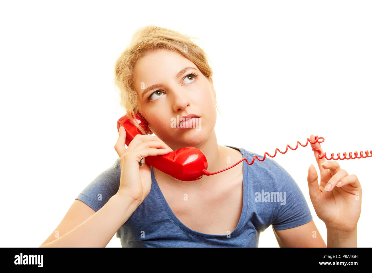 Giovane donna sente frustrato la musica di sottofondo in un telefono loop di attesa Foto Stock