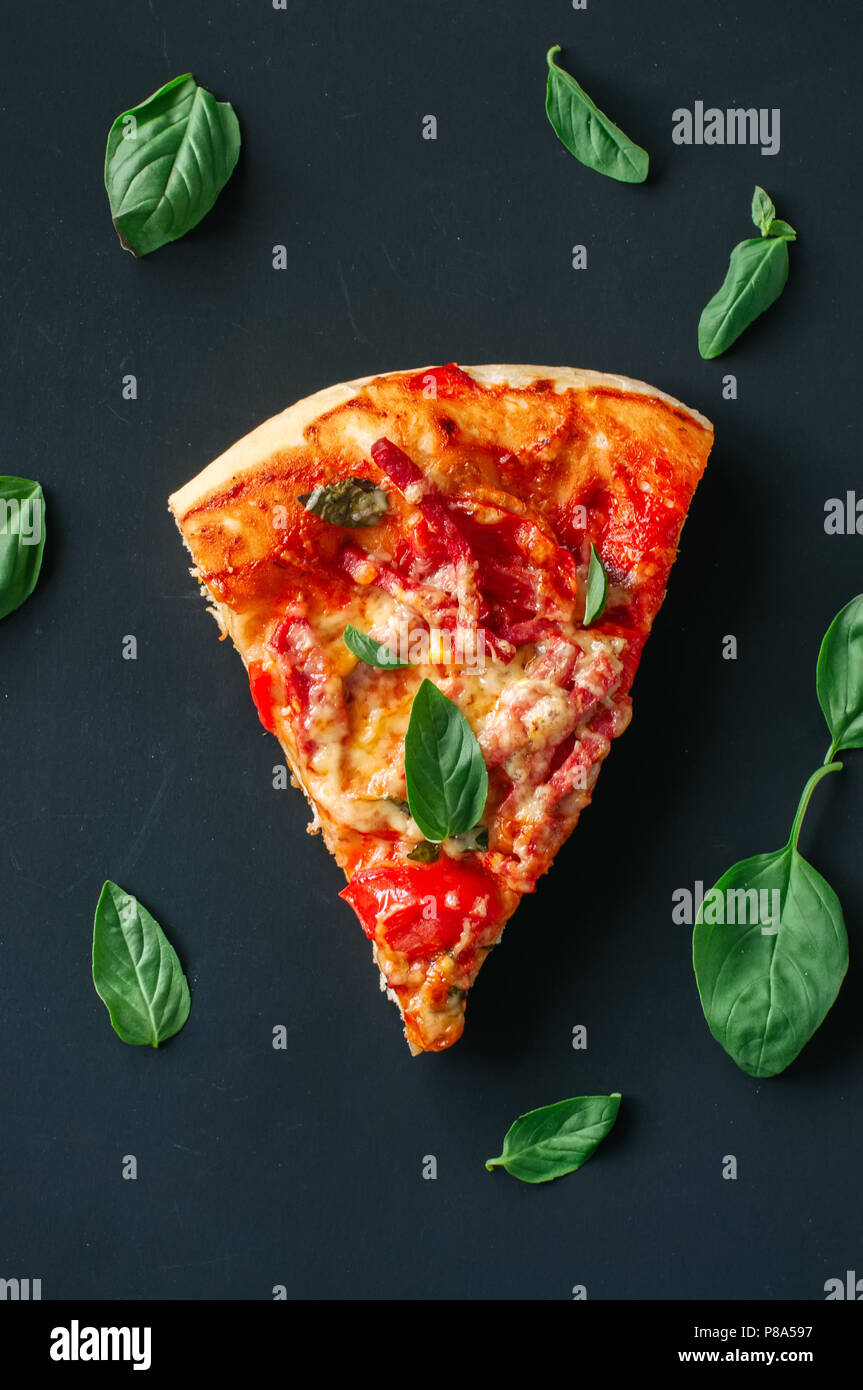 Un pezzo di salame pizza su sfondo nero. Vista superiore, piana, laici copia spazio. Foto Stock