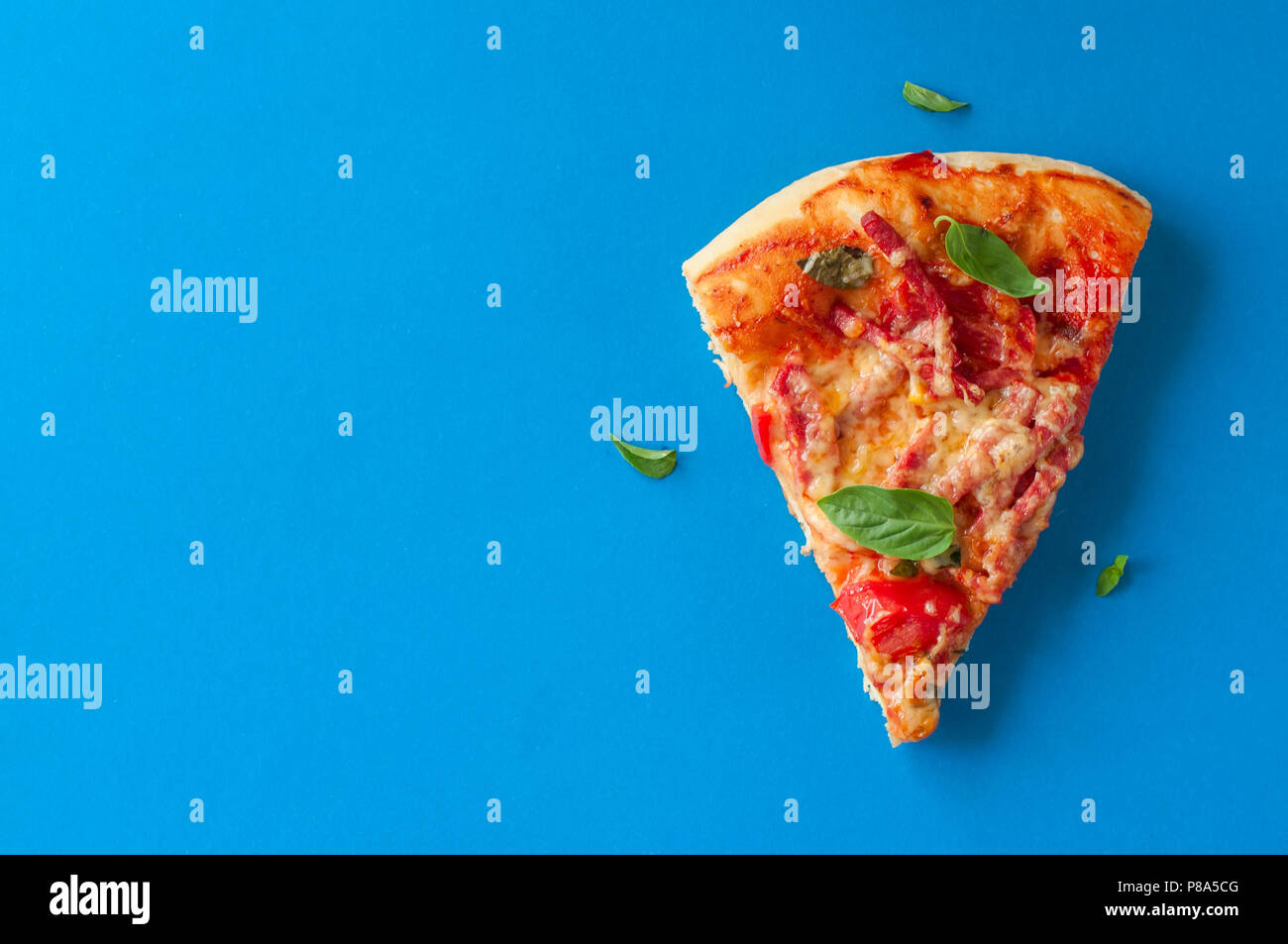 Un pezzo di salame pizza su sfondo blu. Vista superiore e spazio di copia. Foto Stock