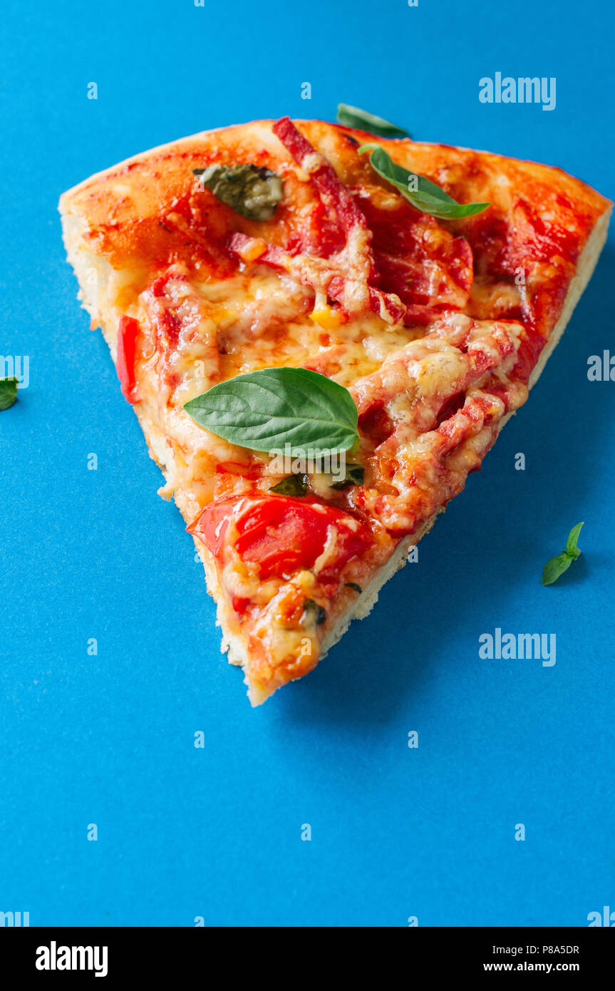 Un pezzo di salame pizza su sfondo blu. Vista superiore Foto Stock
