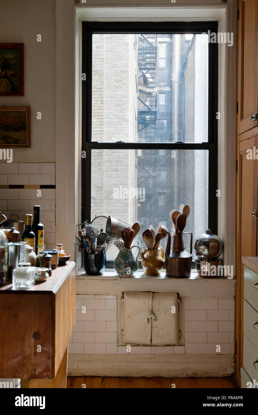 Utensili di cottura memorizzati in un assortimento di brocche e vasi lungo un appartamento di New York davanzale Foto Stock Utensili di cottura memorizzati in un assortimento di brocche e vasi lungo un appartamento di New York davanzale Foto Stock
